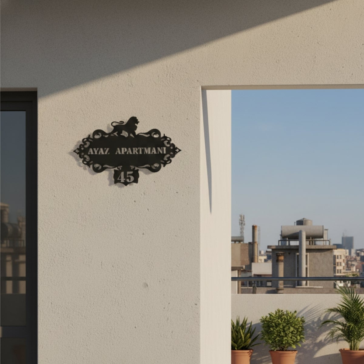 Beyaz dış cephe duvarında bulunan, siyah metal dekoratif apartman ve bina tabelası.