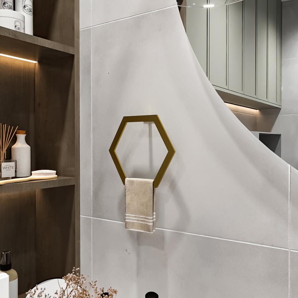 Gri bir banyo duvarına monte edilmiş, bej bir havluyu tutan, dekorasyona lüks bir dokunuş katan altın altıgen şeklinde bir havlu halkası