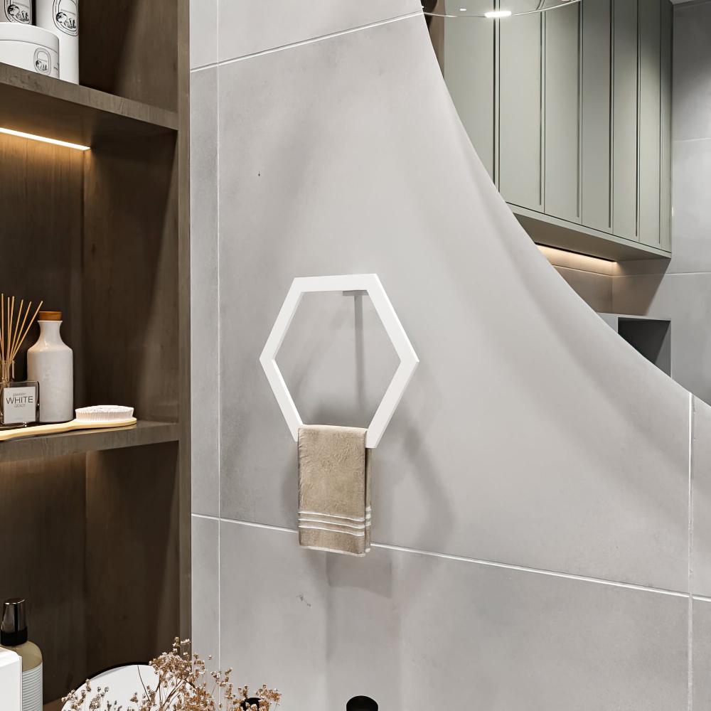 Dekoratif eşyalar ve modern aydınlatmalarla ahşap rafların yanında, bej bir havluyla gri bir banyo duvarında sergilenen beyaz altıgen havlu halkası.