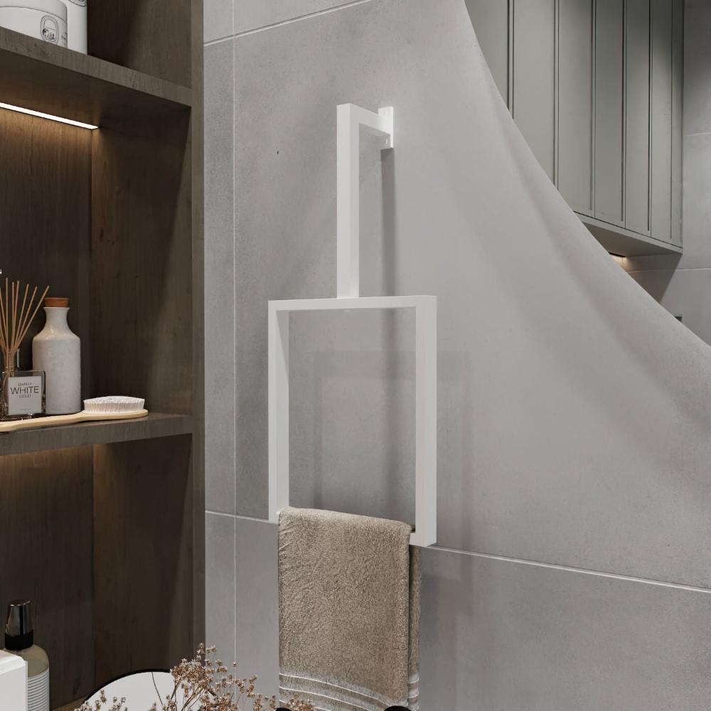 Açık gri bir duvara monte edilmiş minimalist beyaz renkli dikey bir havlu halkası. Modern dikdörtgen tasarım, bej bir havlu tutarak banyo dekoruna temiz ve şık bir dokunuş katıyor. Şık havlu halkası, çevredeki nötr tonları ve sade tasarım öğelerini mükemmel bir şekilde tamamlayarak mekanın minimalist estetiğini güçlendiriyor.