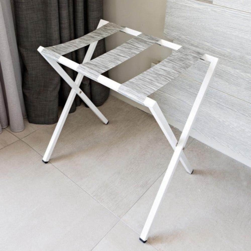 Minimalist bir iç mekanda gri kayışlara sahip, şık ve modern tasarımlı beyaz katlanabilir metal bavul sehpası.