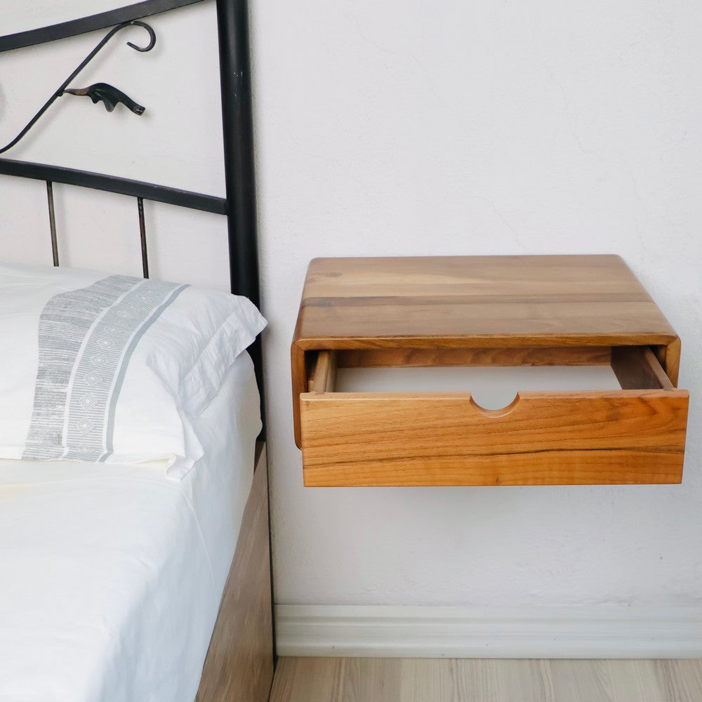 Duvara monte ahşap komodinin açık çekmecesi, geniş depolama alanını sergiliyor. Pürüzsüz doğal ahşap kaplama, minimalist yatak odası dekoruna sıcak ve modern bir dokunuş katıyor.