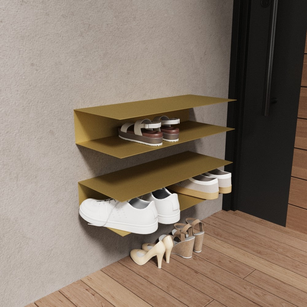 Ahşap zeminli ve minimalist dekora sahip bir antrede şık ve eşsiz bir dokunuş sunan, üç raflı altın renkli, duvara monte yatay ayakkabılık.
