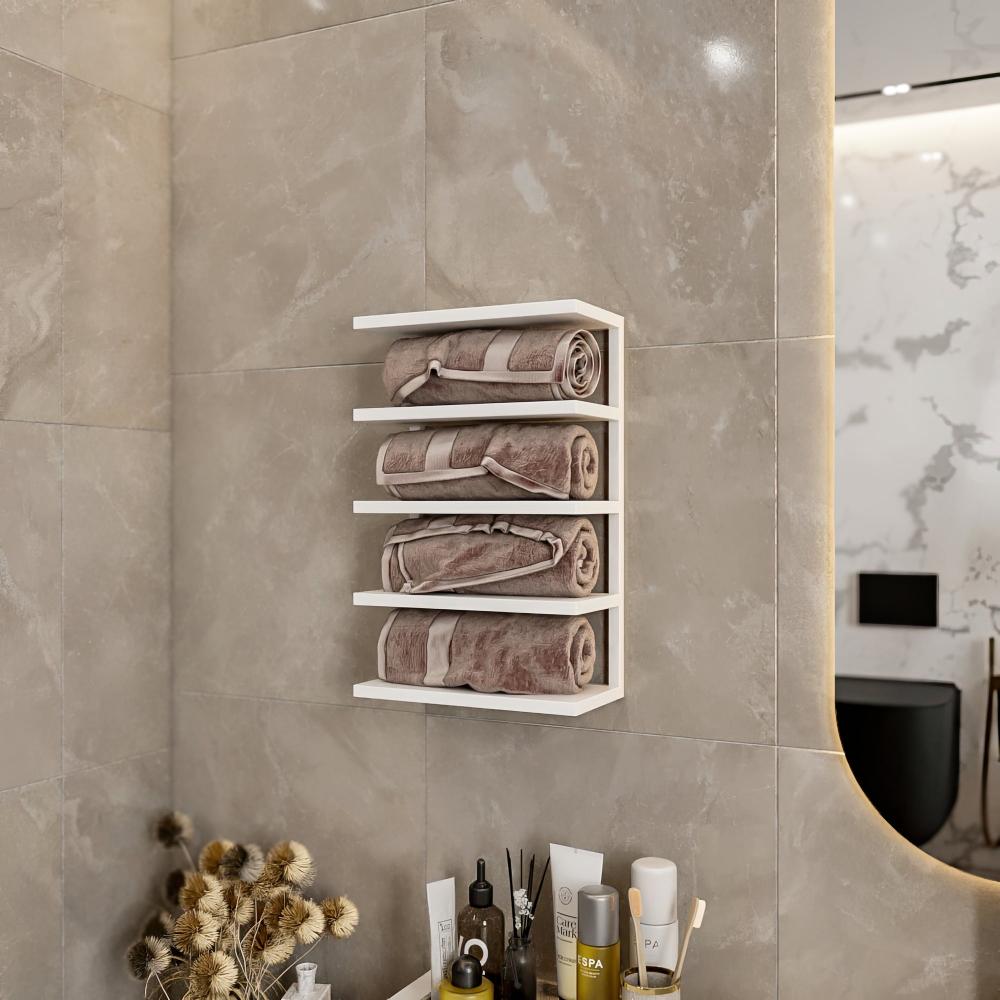Beyaz duvar askılı havluluk, modern bir banyo ortamında düzenli sarılmış bej havluları tutuyor. Şık tasarımı, nötr tonlu fayans duvarı ve minimalist dekoru tamamlıyor. Rafın altında, spa malzemeleri ve kurutulmuş çiçeklerden oluşan bir koleksiyon zarafet ve işlevsellik katıyor.