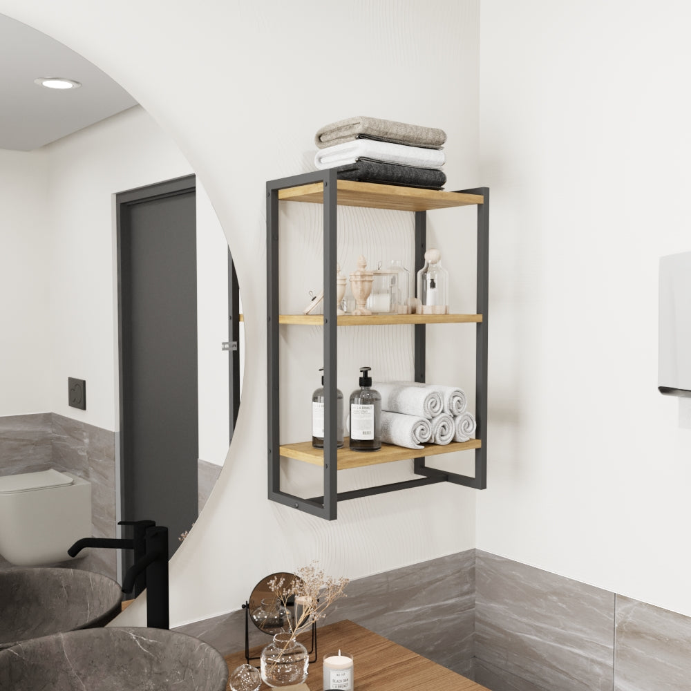 Duvara monte edilmiş, üç ahşap rafa sahip siyah metal bir havluluk. Raflarda katlanmış ve rulo yapılmış havlular, ayrıca banyo eşyaları ve sabunluklar düzenli bir şekilde sergilenmektedir.
