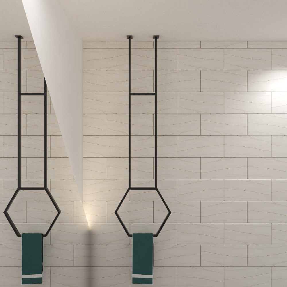 Aydınlık, minimalist bir banyoda, her biri camgöbeği rengi bir havlu tutan, modern tasarımı tamamlayan iki adet siyah altıgen tavana monte havluluk.