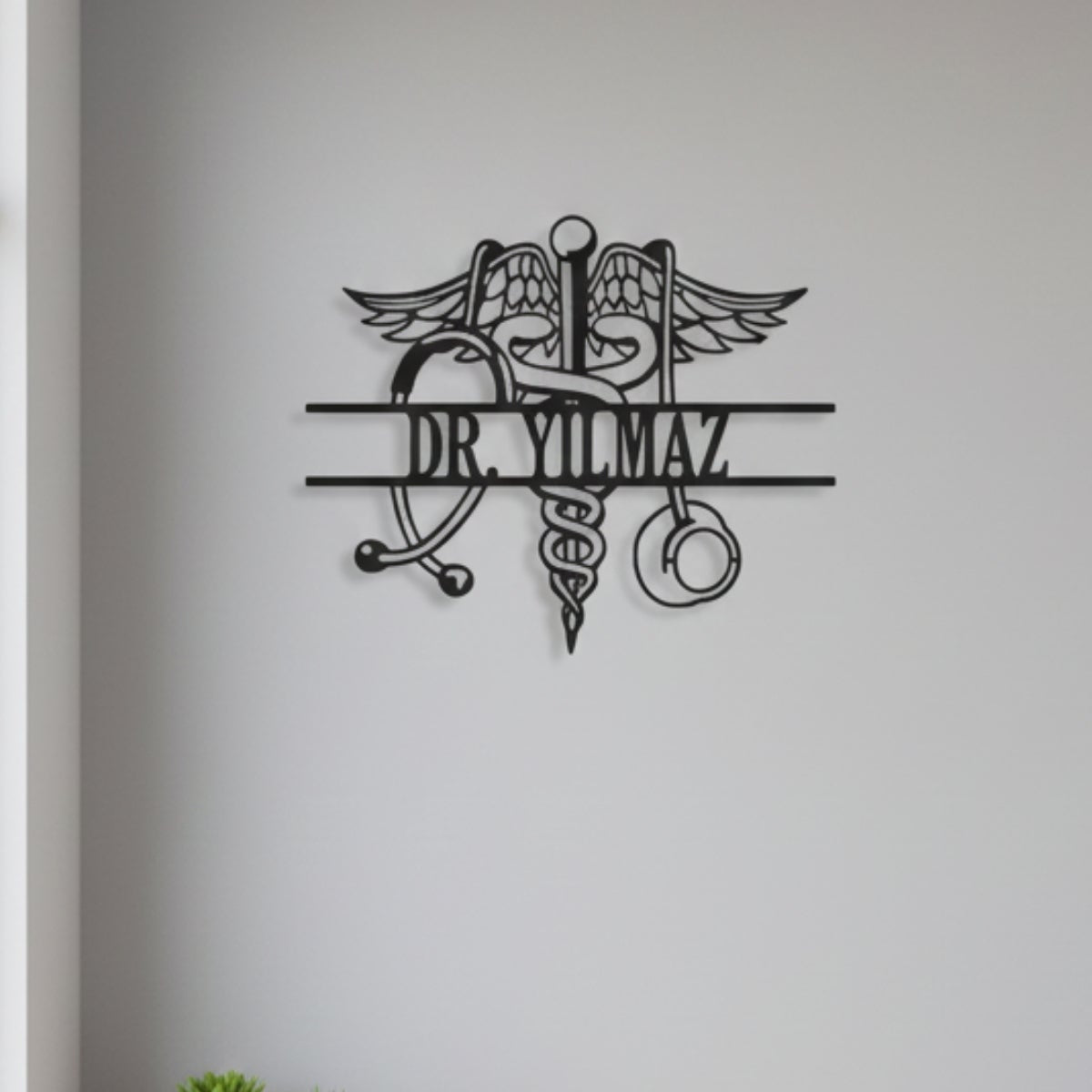 Merkezinde yılanlı asa ve çevresinde stetoskop figürü bulunan, kişiselleştirilebilir isim alanlı siyah metal tıp dünyası temalı duvar sanatı.