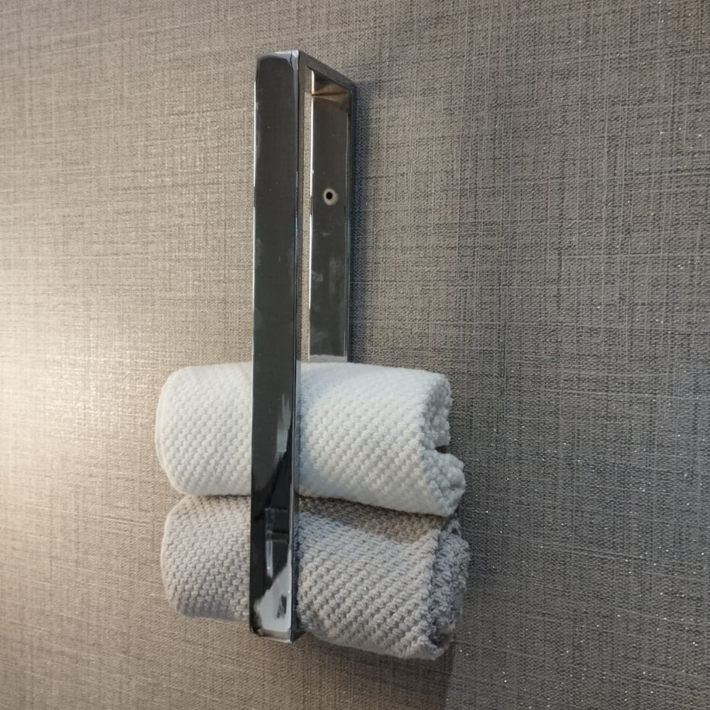 Modern ve düzenli bir estetik yaratan, krom havluluk, havlular ve şık bir aydınlatma armatürü içeren bir banyo duvarı.