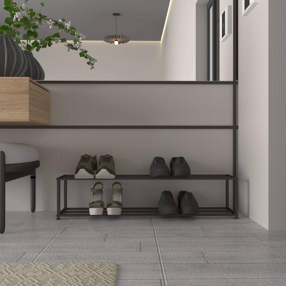 Modern bir giriş alanına yerleştirilmiş, üç çift ayakkabıyı düzenli bir şekilde tutan, arka planda dekoratif bir bitki ve çağdaş tasarım öğeleri bulunan minimalist iki katlı metal ayakkabılık.