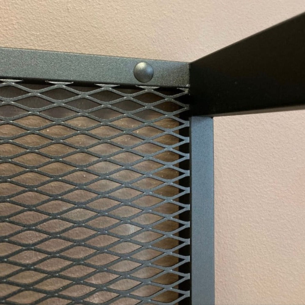 Sağlam siyah file ve metal yapım detaylarını gösteren, duvara monte bir odunluğun üst köşesinin yakın çekimi.