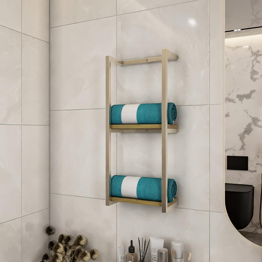 Koyu taş fayanslı bir duvara monte edilmiş, düzenli bir şekilde katlanmış mavi havluları tutan, modern bir estetik yaratan, açık ahşap tabanlı paslanmaz çelik metal banyo rafı.