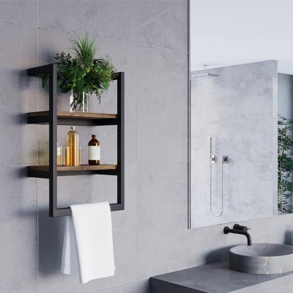 Modern bir banyo lavabosu ve aynasının yanına yerleştirilmiş, minimalist bir bitki ve cam şişe düzenlemesine sahip, iki ahşap katmanlı siyah duvara monte bir raf.