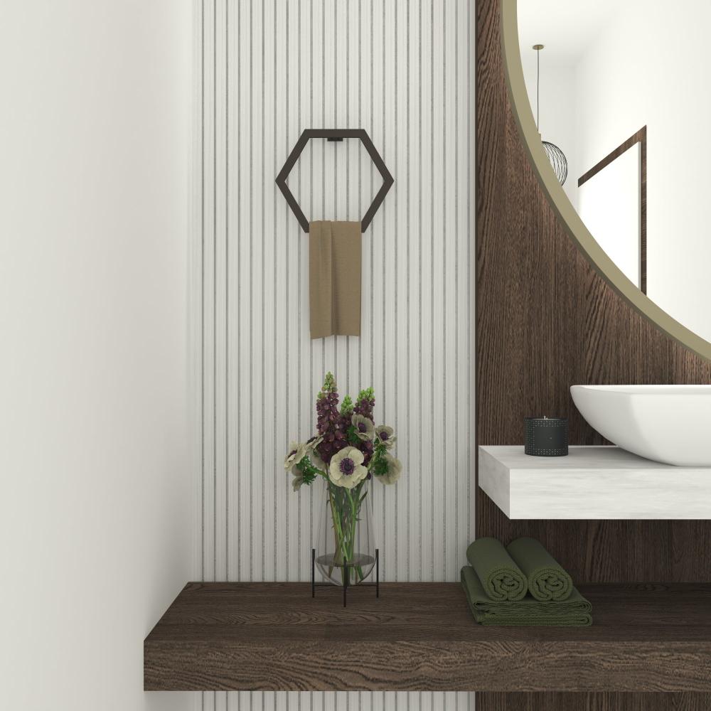 Bir vazo çiçek ve ahşap raf üzerindeki yuvarlak bir aynanın yanında, bej bir havluyla banyo duvarına monte edilmiş siyah altıgen havlu tutucu.