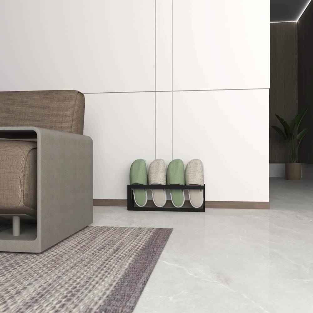 Modern bir oturma odası köşesinde, minimalist bir dekorasyon tarzıyla dört çift terliği düzenli bir şekilde tutan siyah metal bir terlik rafı.