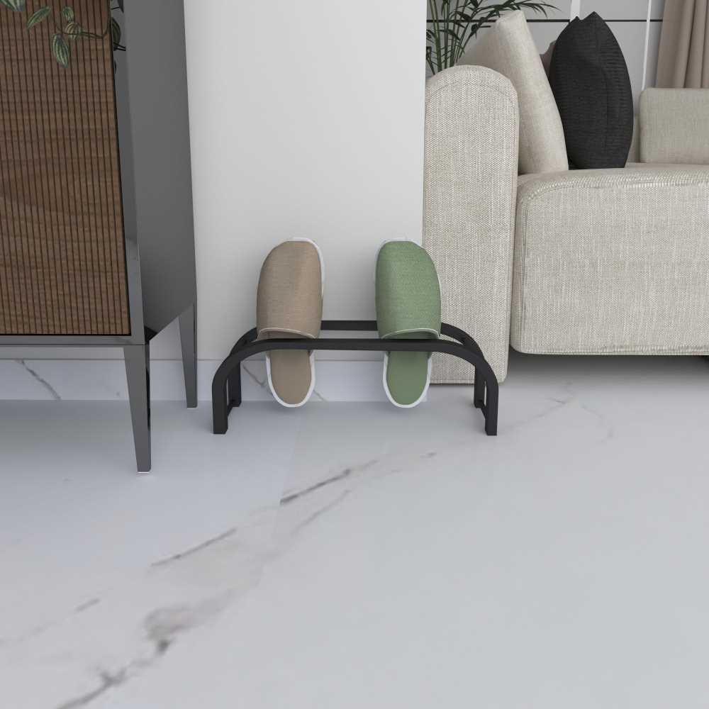 Mermer bir zeminde, modern bej bir kanepe ve minimalist mobilyaların yanında sergilenen, yeşil ve bej terlikleri tutan kompakt siyah bir terlik rafı.