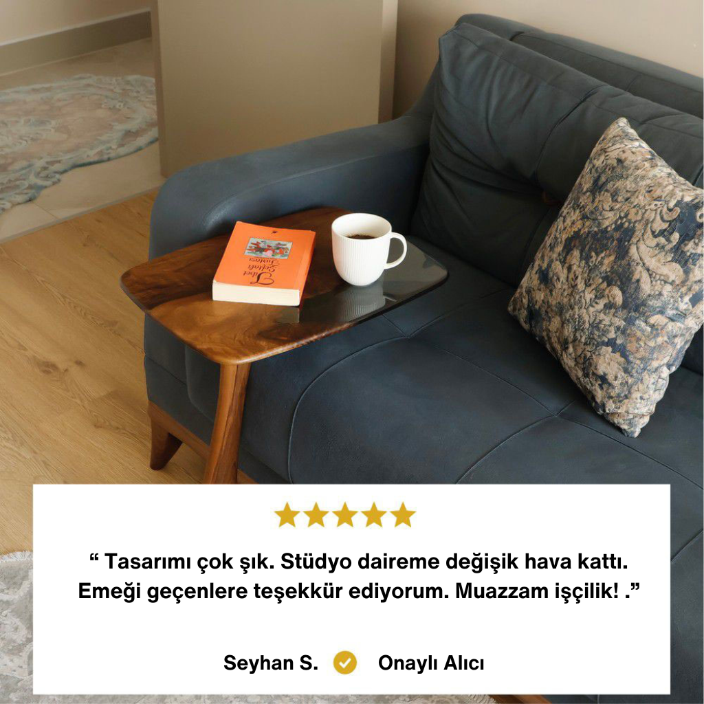 Ceviz ağacı görünümlü, modern koltuk yanı sehpası üzerinde kitap ve kahve fincanı. Alt kısımda Seyhan S. adlı Onaylı Alıcı yorumu: "Tasarımı çok şık. Stüdyo daireme değişik hava kattı. Muazzam işçilik!"