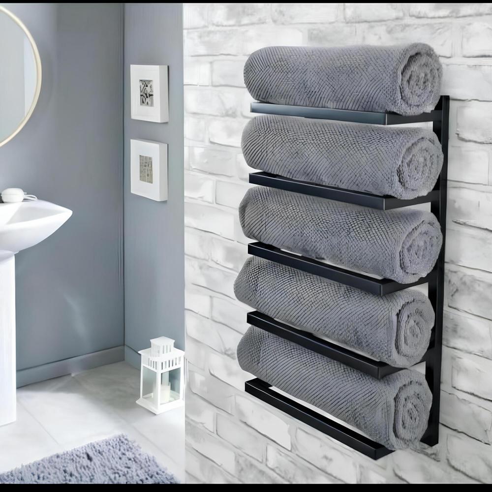 Duvara monte beş katlı siyah havluluk, modern bir banyoda yuvarlak ayna ve minimalist dekorla beyaz tuğla duvara karşı rulo gri havluları tutuyor.