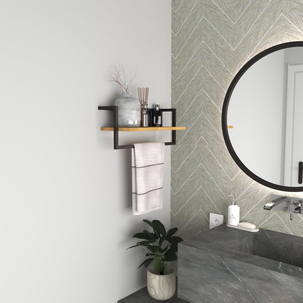 Mat siyah metal çerçeveli ve ahşap plakalı, vazo ve bambu çubuklu difüzörler gibi dekoratif objeleri taşıyan modern bir banyo rafı; altında asılı bir havlu bulunuyor.