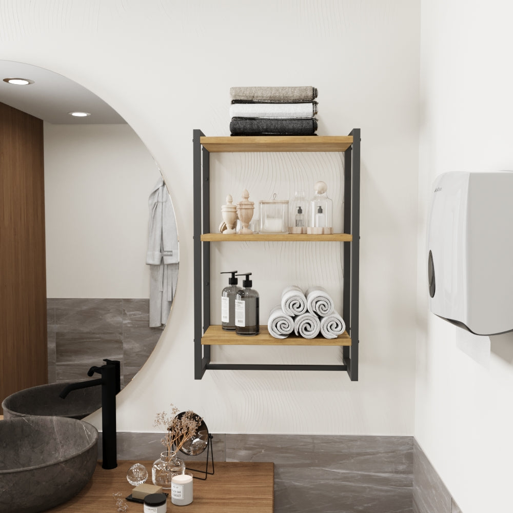 Duvara monte edilmiş, üç ahşap rafa sahip siyah metal bir havluluk. Raflarda katlanmış ve rulo yapılmış havlular, ayrıca dekoratif cam şişeler ve sabunluklar düzenli bir şekilde sergilenmektedir.