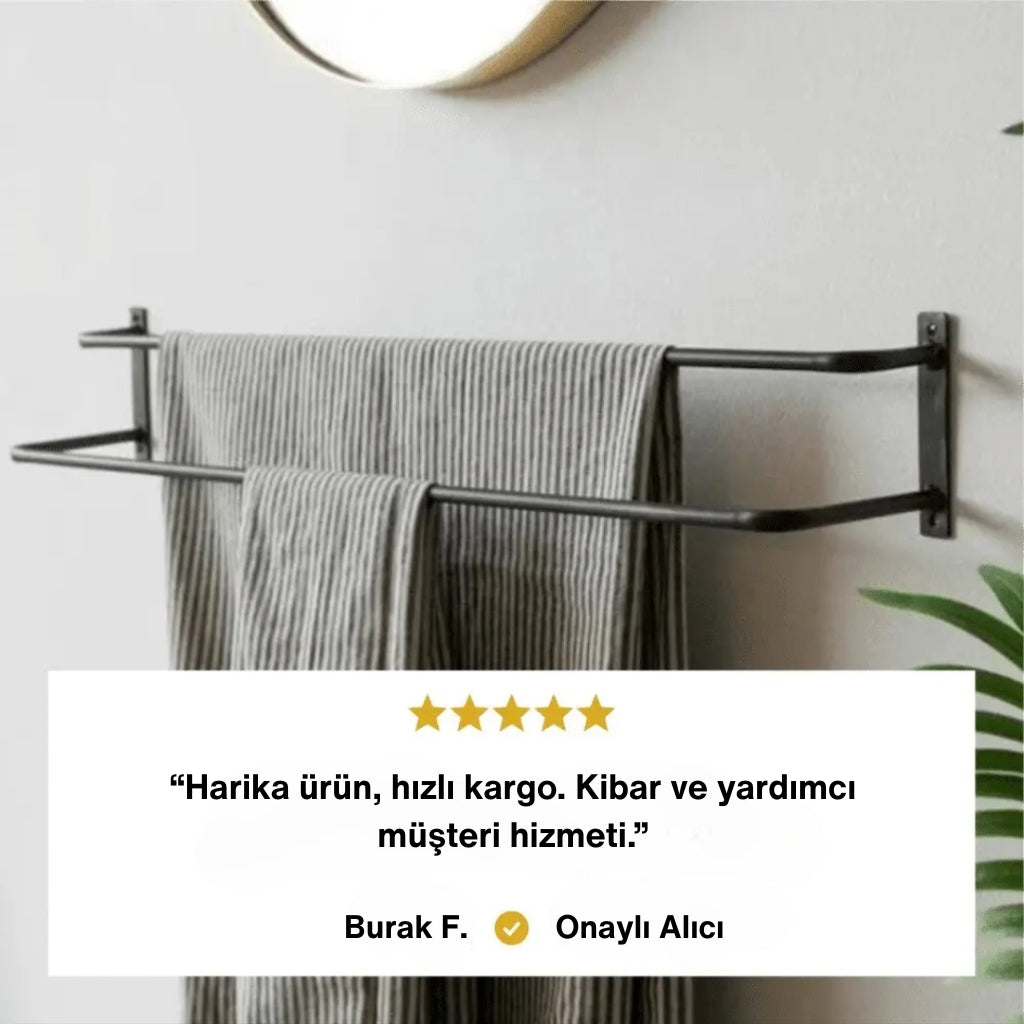 Duvara monte edilmiş siyah metal havluluk üzerinde gri çizgili havlular asılıdır. Alt kısımda beş yıldızlı bir müşteri yorumu yer alır: “Harika ürün, hızlı kargo. Kibar ve yardımcı müşteri hizmeti.” Yorumun altında “Burak F. - Onaylı Alıcı” ifadesi bulunur.