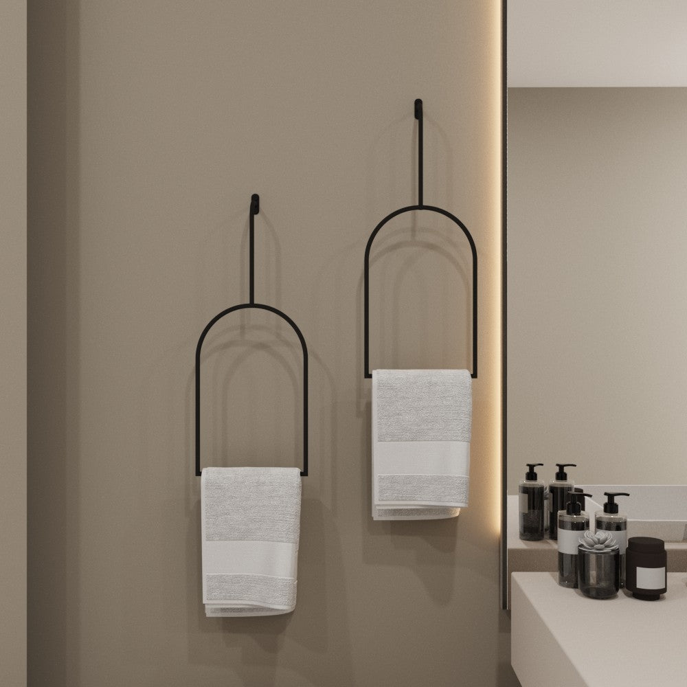 İki minimalist havlu halkası banyo ortamında yan yana monte edilmiş, her biri beyaz bir havlu tutuyor, dekora zarafet ve pratiklik katıyor.