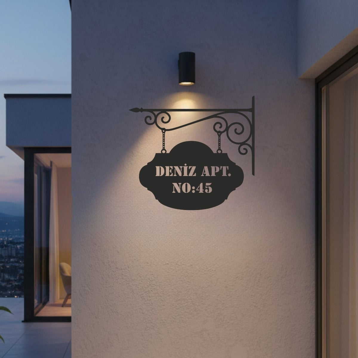 Kıvrımlı ferforje askı koluna zincirlerle bağlı, üzerinde "Deniz Apt. No:45" yazılı klasik tasarımlı siyah metal adres levhası.