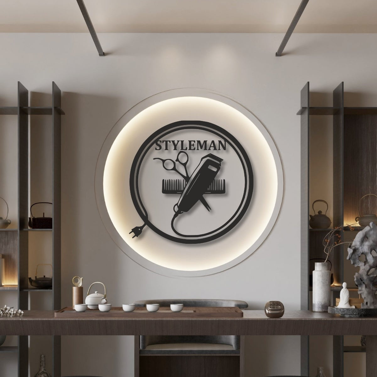Erkek kuaförleri için tasarlanmış, dairesel çerçeve içinde kablolu tıraş makinesi, makas ve tarak figürlerini birleştiren siyah metal duvar sanatı.