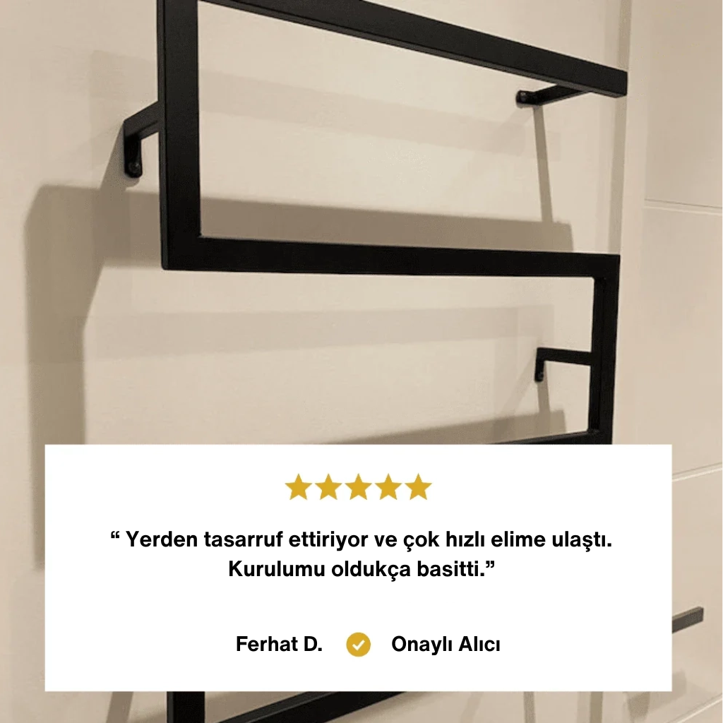 Duvara monte edilmiş, siyah metal zikzak/modern havluluk rafının yakın plan görüntüsü. Alt kısımda Ferhat D. adlı Onaylı Alıcı yorumu: "Yerden tasarruf ettiriyor, hızlı ulaştı ve kurulumu oldukça basitti."