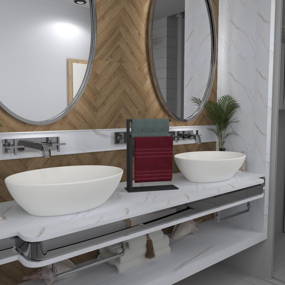 Zıt renklerde özenle katlanmış iki havluyu tutan, iki oval ayna arasında bir banyo tezgahında sergilenen, modern tasarımlı siyah bir tezgah üstü havluluk, dekora zarafet katıyor.