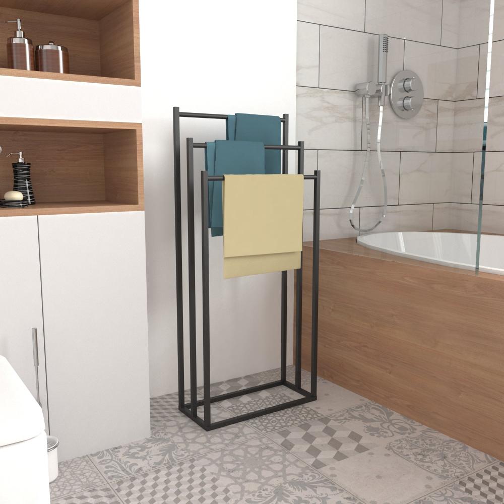 Çağdaş bir banyo ortamında havluları tutan, şık siyah metal çerçeveli modern, ayaklı bir havluluk.
